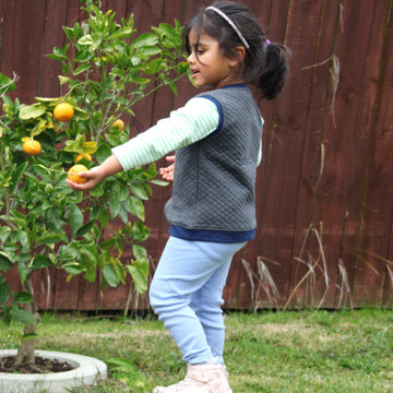 Little girl wearing organic cotton green striped tshirt