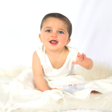 Baby with natural organic cotton swaddle blanket